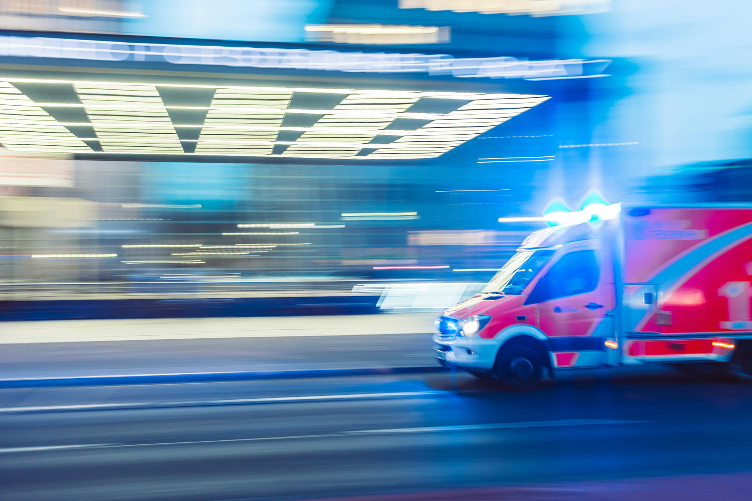 Ambulance with blue lights on a city street at night